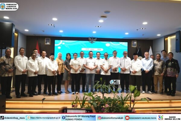 Suasana Rakernas APKASI XVII dengan Heriyus, Sarman Simanjorang, dan Delis Julkarson Hehi berdiri di depan panggung, berlatar layar biru.