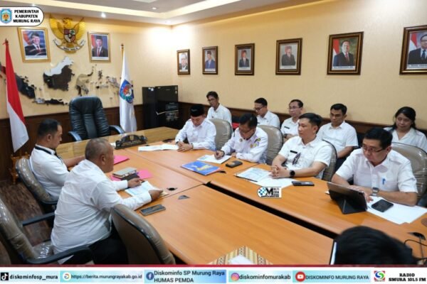 Koordinasi Pemkab Murung Raya dalam audiensi ke Kemendagri RI, Rahmanto Muhidin dan Nasrun duduk di ruang rapat dengan seragam putih dan meja kayu.