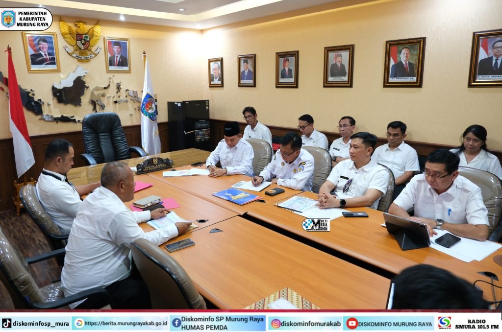 Koordinasi Pemkab Murung Raya dalam audiensi ke Kemendagri RI, Rahmanto Muhidin dan Nasrun duduk di ruang rapat dengan seragam putih dan meja kayu.