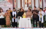 Handreas Paron hadir di perayaan Paskah Murung Raya di Puruk Cahu dengan jemaat mengenakan pakaian formal berwarna-warni, di sekitar meja kue bertingkat serta latar banner gereja