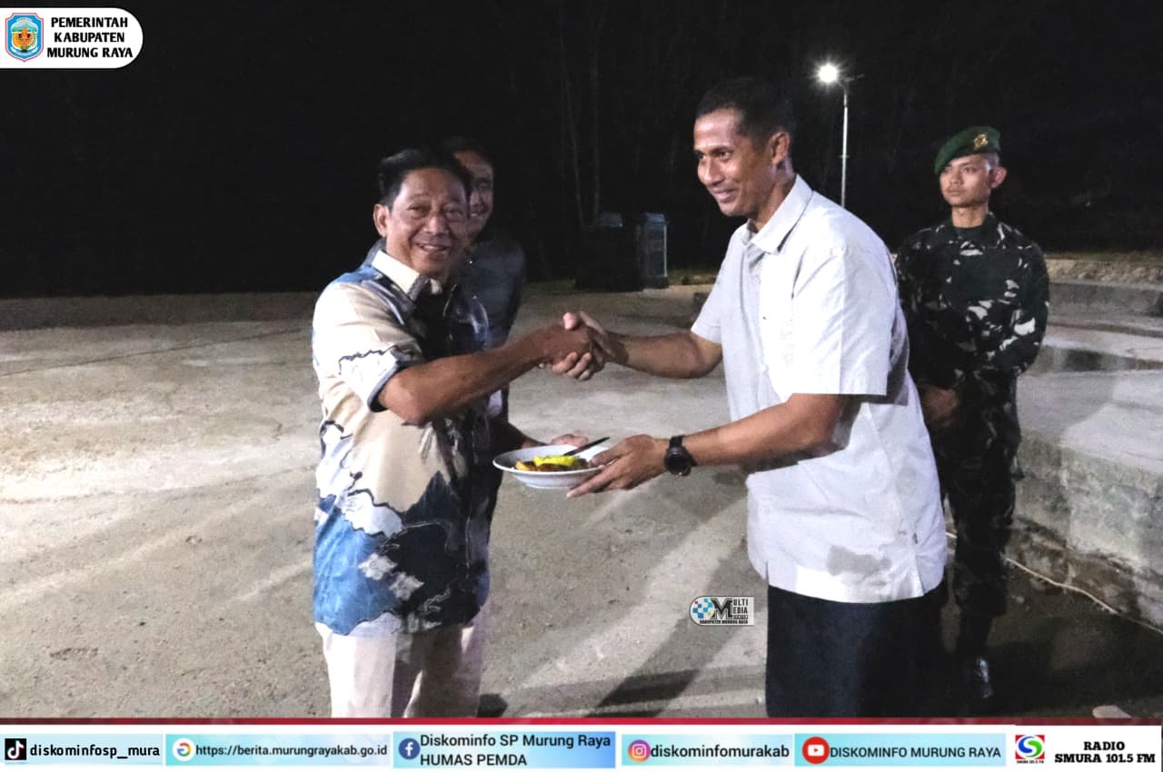 Bupati Murung Raya Heriyus berjabat tangan dengan Letkol Inf Supriyanto pada acara syukuran kenaikan pangkat Yonif 883/TA di malam hari, disaksikan anggota tentara di latar belakang