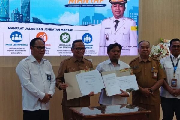 Sekelompok pejabat menyodorkan dokumen nota serah terima dalam acara BPJN, dipimpin H M Noor Rifani, dengan kemeja putih dan seragam cokelat.