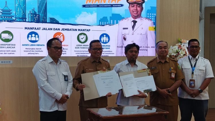 Sekelompok pejabat menyodorkan dokumen nota serah terima dalam acara BPJN, dipimpin H M Noor Rifani, dengan kemeja putih dan seragam cokelat.