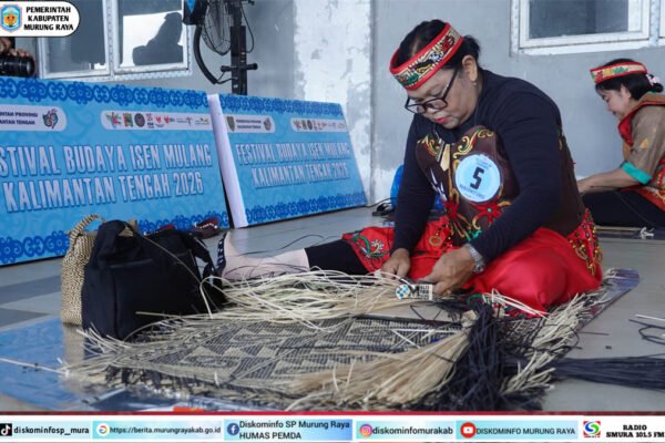 Seorang peserta Manjawet Uwei dari kontingen Murung Raya bekerja merangkai rotan dengan fokus tinggi memakai pakaian merah di FBIM 2026.
