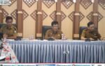 Rapat desk rencana penyaluran TDF Tahap I Pemkab Murung Raya berlangsung di aula Bapperida, Sarwo Mintarjo memimpin dengan seragam cokelat di meja rapat.