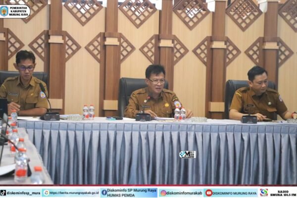 Rapat desk rencana penyaluran TDF Tahap I Pemkab Murung Raya berlangsung di aula Bapperida, Sarwo Mintarjo memimpin dengan seragam cokelat di meja rapat.