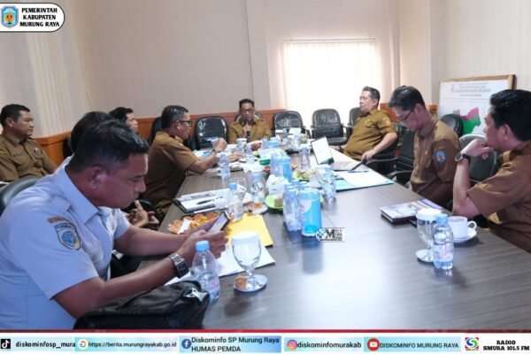 Bupati Murung Raya Heriyus memimpin rapat arahan pelelangan fisik proyek pembangunan dengan Stardian dan jajaran di aula, meja rapat berisi dokumen