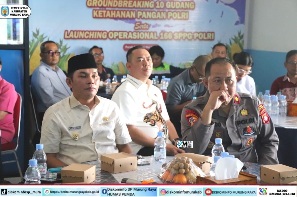 Rahmanto Muhidin duduk bersama Polres Murung Raya dalam acara Polri, dengan kemeja putih dan seragam polisi, serta suasana rapat di meja pertemuan.