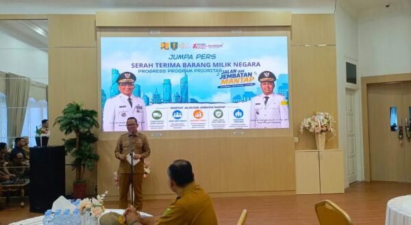 Ir H M Noor Rifani SH ST MT menyampaikan keterangan dalam jumpa pers di ruang tertutup, dengan banner program dan sosialisasi E-lapor serta TRC.