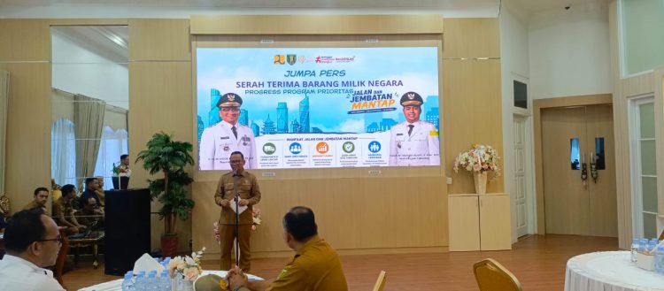 Ir H M Noor Rifani SH ST MT menyampaikan keterangan dalam jumpa pers di ruang tertutup, dengan banner program dan sosialisasi E-lapor serta TRC.