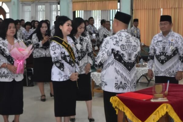 Mimie Mariatie Jaya S. Monong menerima selendang berwarna kuning saat prosesi pelantikan Ibunda Guru Kabupaten Gunung Mas dengan batik putih-hitam.