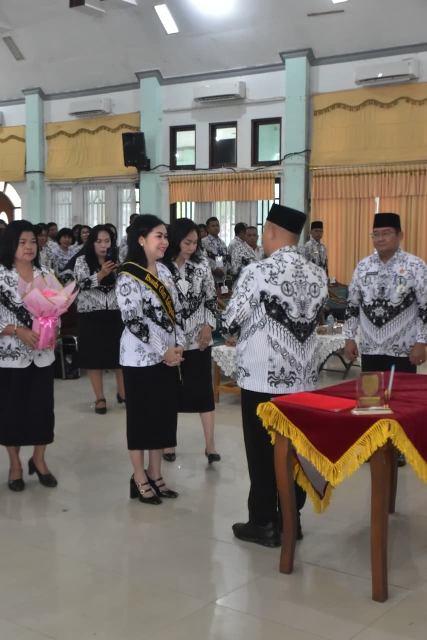 Mimie Mariatie Jaya S. Monong menerima selendang berwarna kuning saat prosesi pelantikan Ibunda Guru Kabupaten Gunung Mas dengan batik putih-hitam.