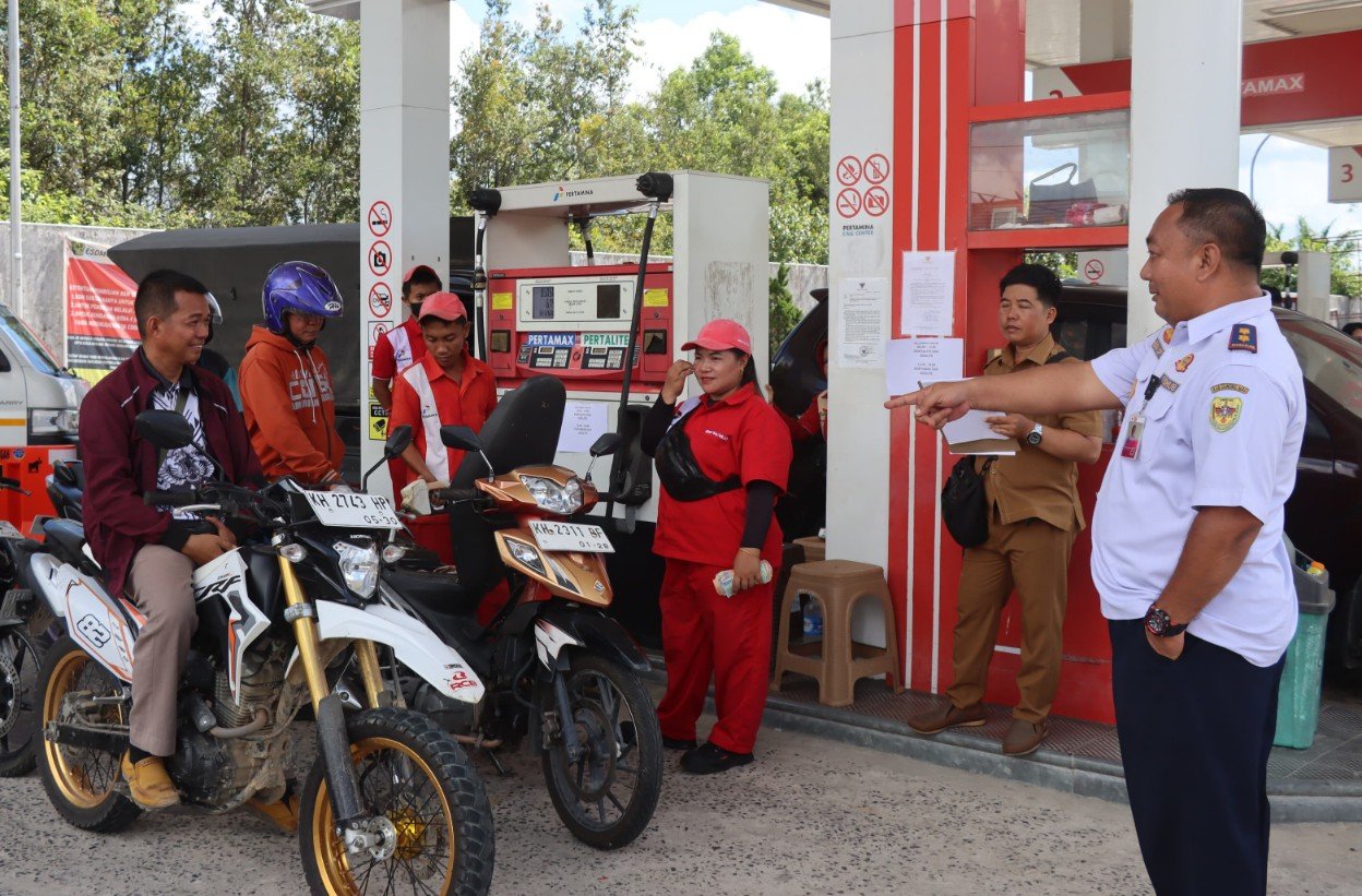 Petugas melakukan pengawasan BBM di SPBU berwarna merah-putih di Kuala Kurun, Gunung Mas, saat kendaraan mengantre untuk pengisian
