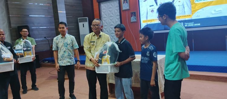 Bupati Tabalong H. Noor Rifani menyerahkan beasiswa dan perlengkapan sekolah kepada tiga anak korban kebakaran di Gedung Informasi Tabalong.