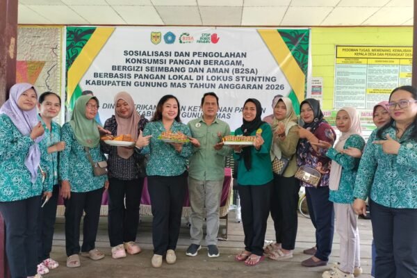 Sejumlah kader TP PKK Gunung Mas dan Dinas Perikanan berpose bersama sambil memegang hidangan olahan pangan lokal pada sosialisasi B2SA di Karya Bakti.