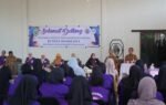 Tim Pembina Posyandu Kalimantan Selatan berdialog dengan kader berpakaian ungu di Gedung Multiguna Desa Muara Jaya, Balangan.