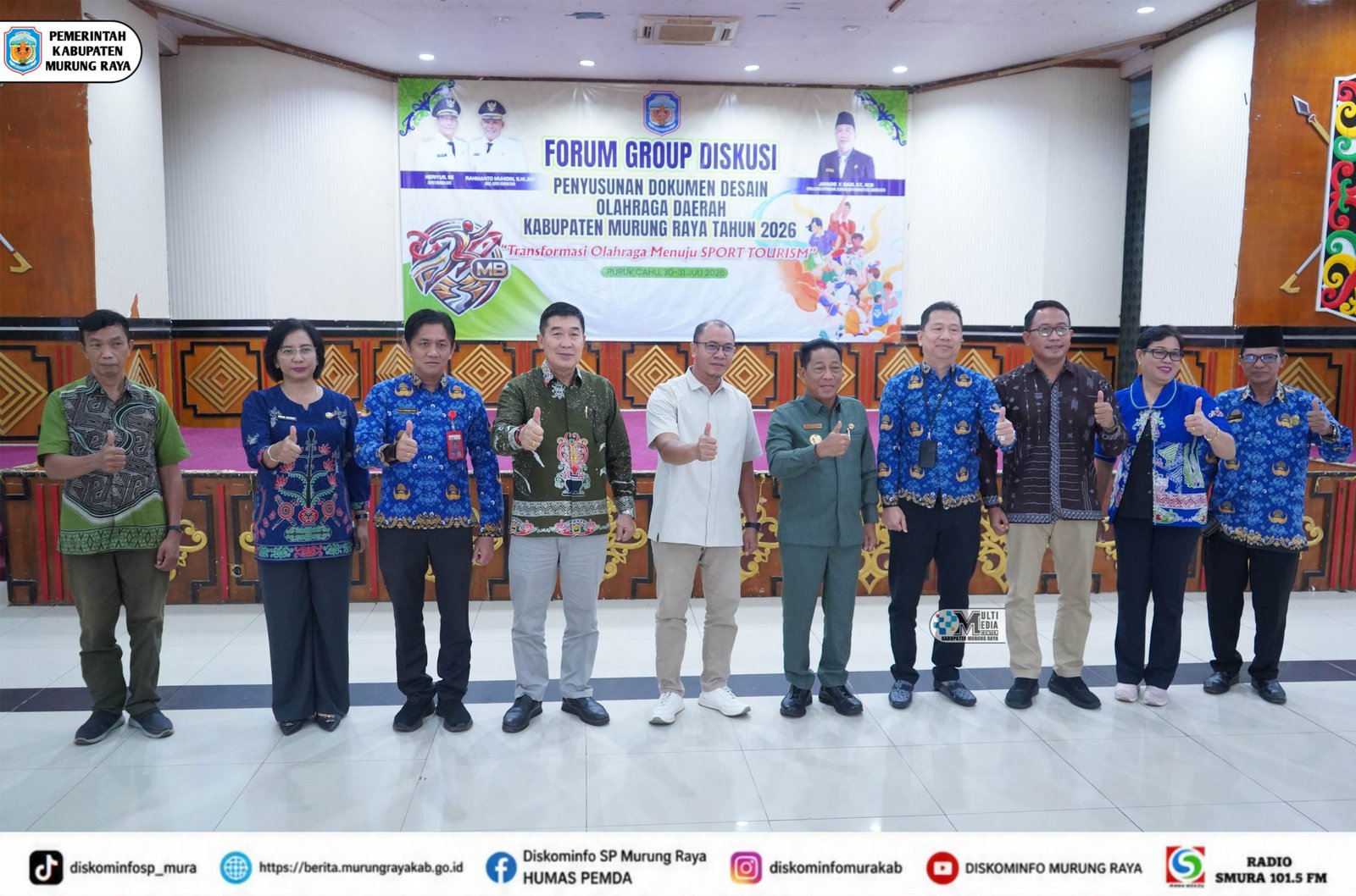 Sepuluh pejabat Murung Raya berdiri bersama sambil memberi salam jempol di depan spanduk FGD Desain Olahraga Daerah 2026.
