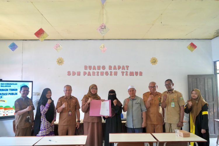 Sejumlah guru dan pejabat berfoto bersama sambil memegang dokumen di ruang rapat SD Negeri Paringin Timur, Balangan.