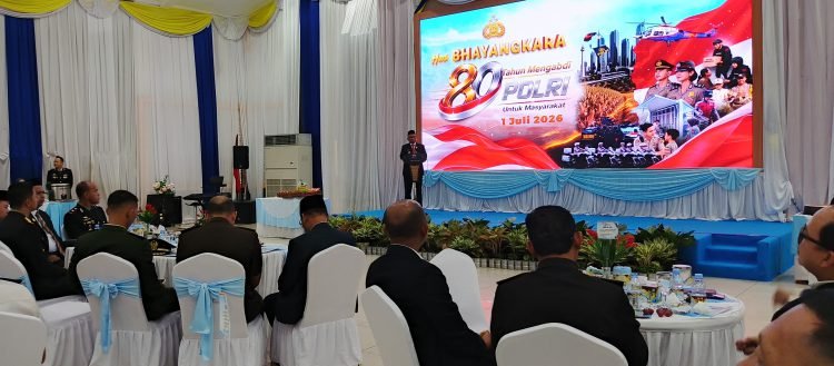 Suasana syukuran Hari Bhayangkara ke-80 di Pendopo Bersinar menampilkan layar besar bertema Polri dan para tamu duduk menyimak acara dengan tertib.