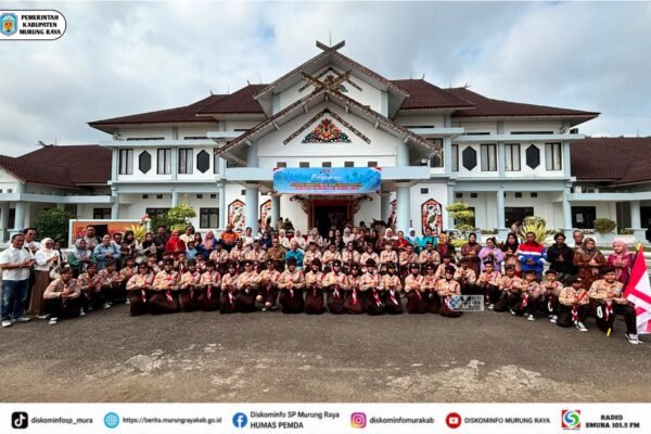 Rombongan peserta dan pembina Pramuka Murung Raya berfoto di depan kantor bupati dengan spanduk Jamnas XII 2026.