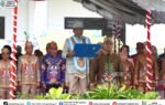 Heriyus membacakan sambutan di podium pada peringatan Hari Jadi ke-24 Kabupaten Murung Raya bersama pejabat berbusana adat.