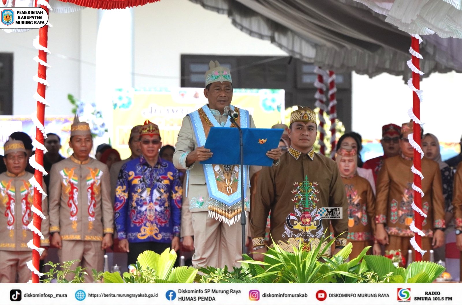 Heriyus membacakan sambutan di podium pada peringatan Hari Jadi ke-24 Kabupaten Murung Raya bersama pejabat berbusana adat.