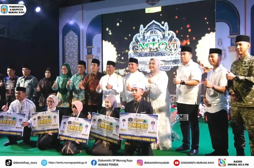 Para pemenang berpose bersama pejabat di panggung penutupan MTQ XI Murung Raya, sambil memegang papan hadiah umrah.