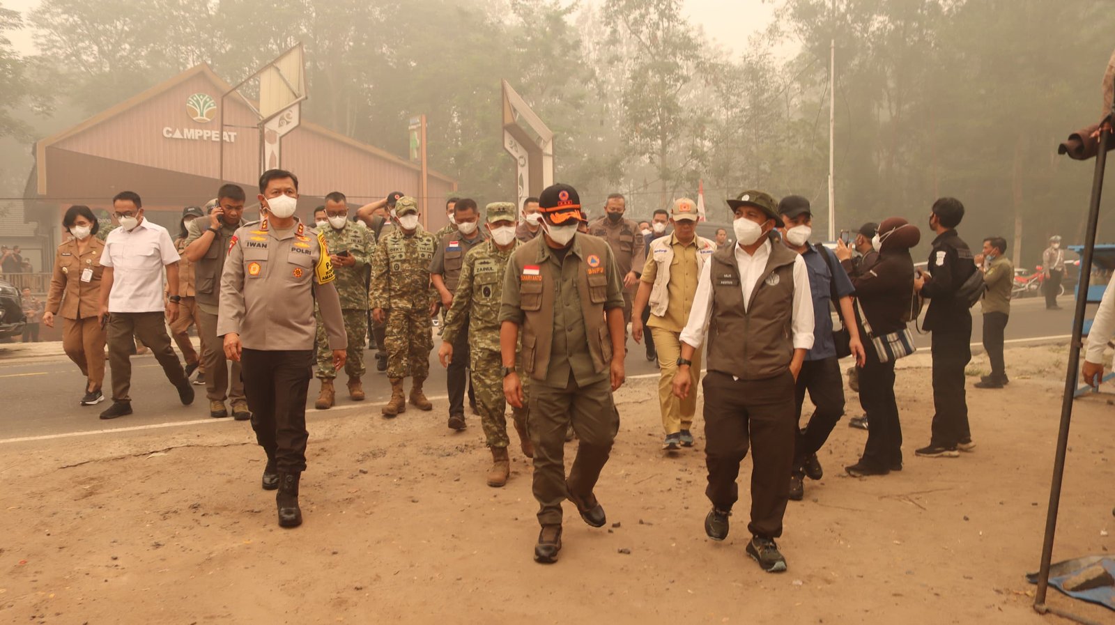 Sejumlah pejabat, personel, dan petugas berjalan dalam kabut asap karhutla di area Camppeat, Kalimantan Tengah.